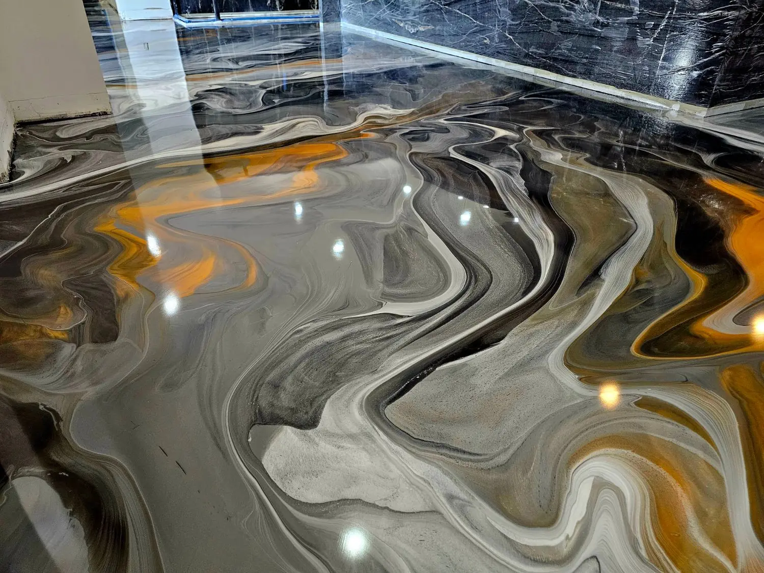 Metallic epoxy floor in orange, black and silver swirls